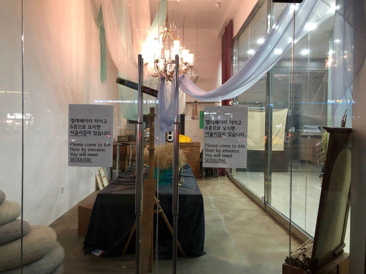 ソウリズムカフェへの道案内の看板が掲示されたビルの内部の写真